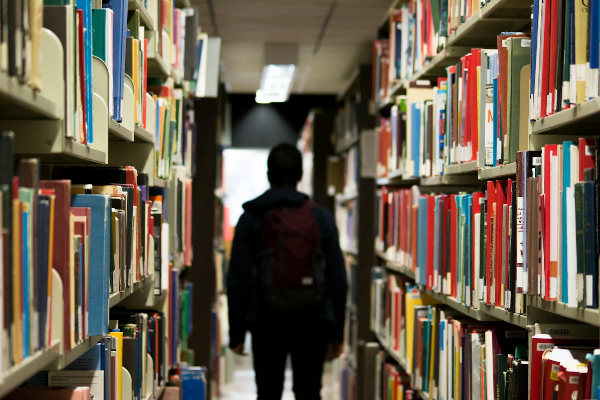 Élève dans une bibliothèque scolaire